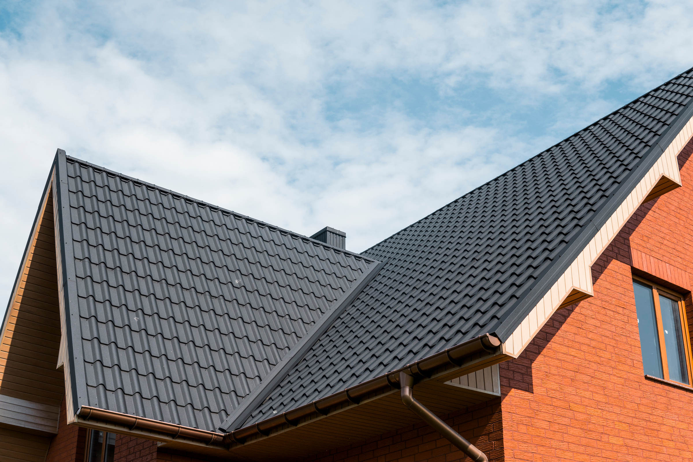 Modern roof covered with tile effect PVC coated brown metal roof sheets.